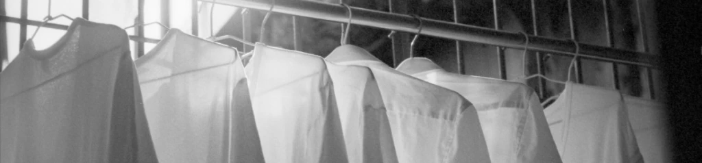 White shirts hanging on a rod.